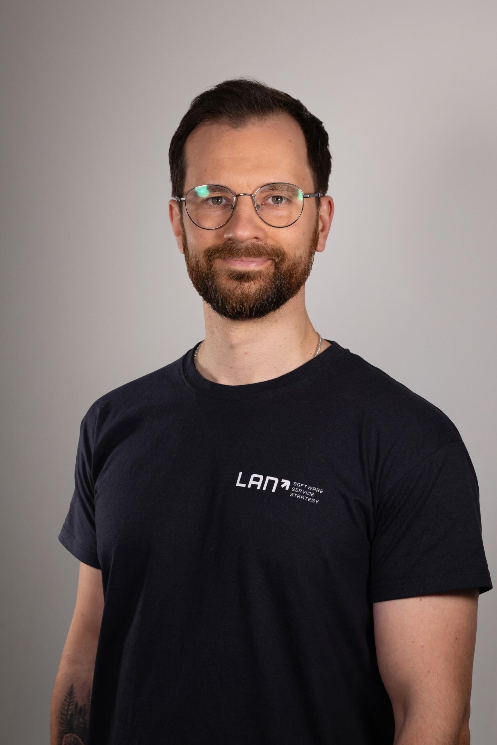 Sage-Support-Mitarbeiter Artur vor neutralem Hintergrund