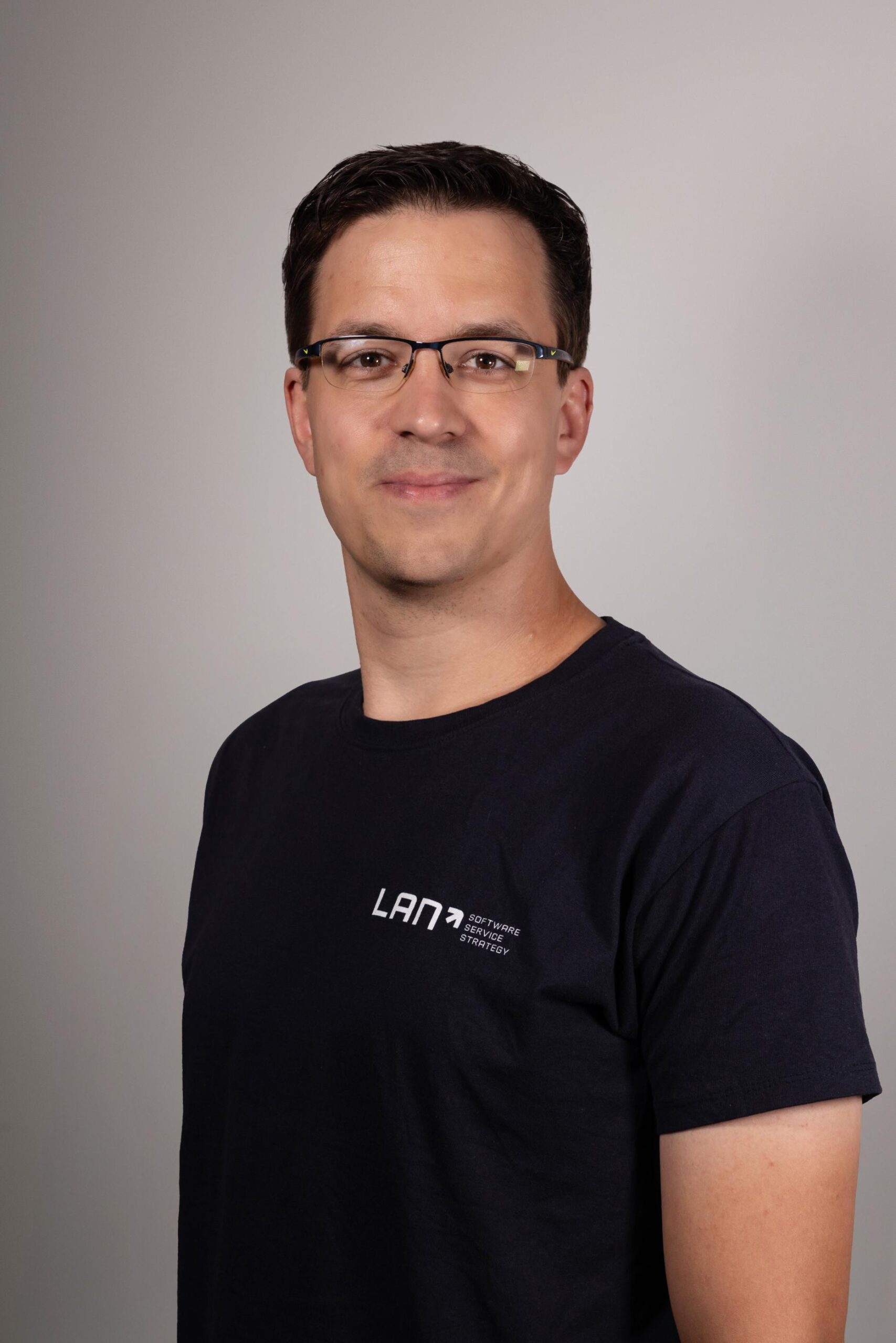 Haus- und Akademiemanager sowie LANcloud Support-Mitarbeiter Jonas vor neutralem Hintergrund.