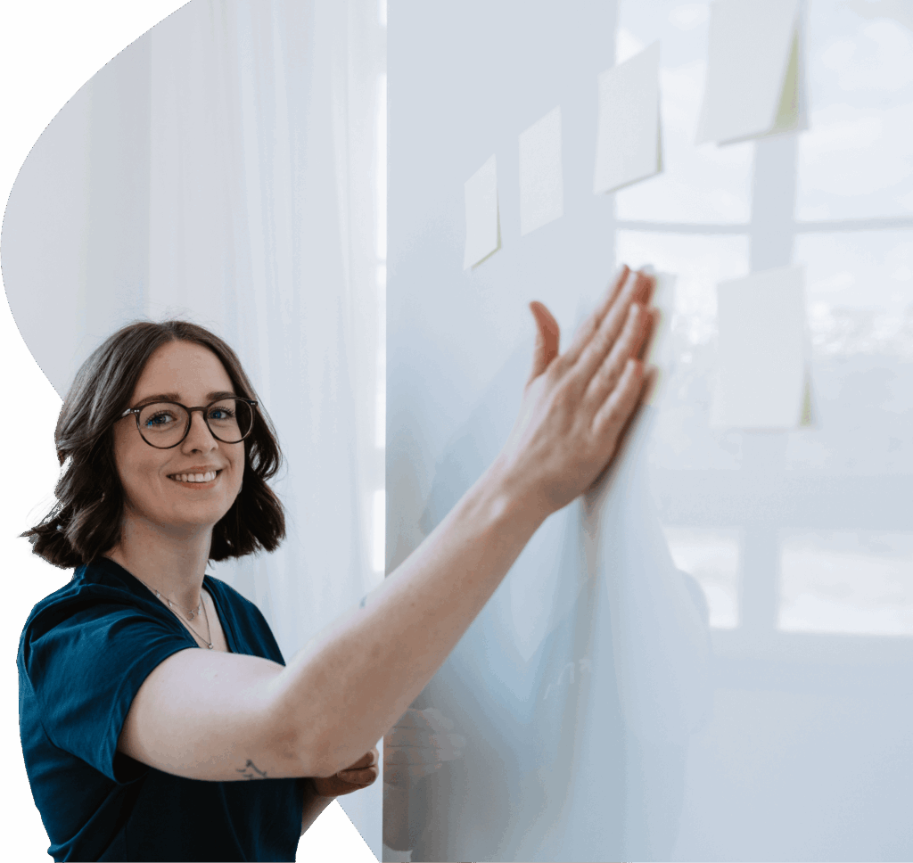 Person plant Veranstaltungen an einem Whiteboard mit Haftnotizen.